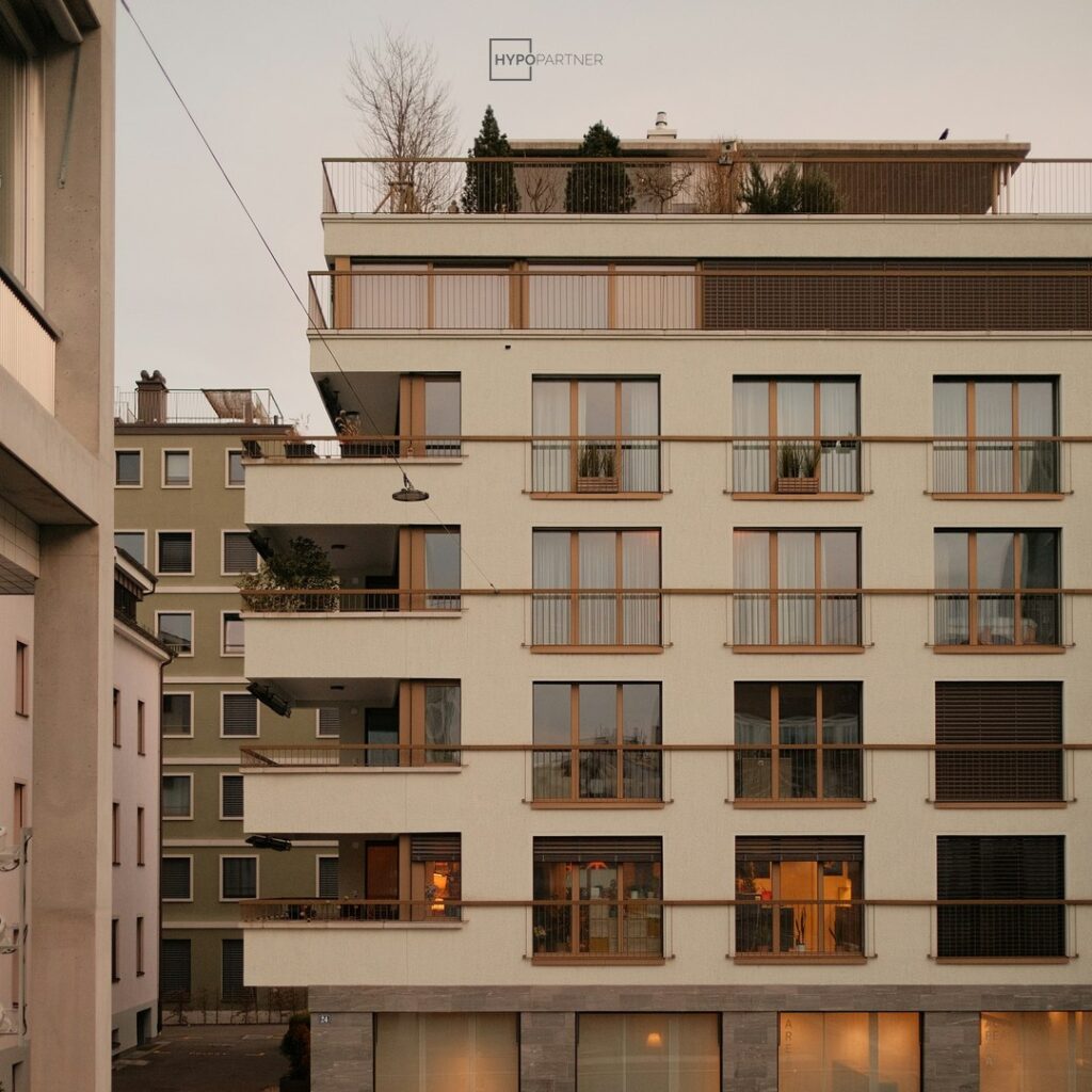 Modernes Mehrfamilienhaus mit Dachterrasse in der Abenddämmerung