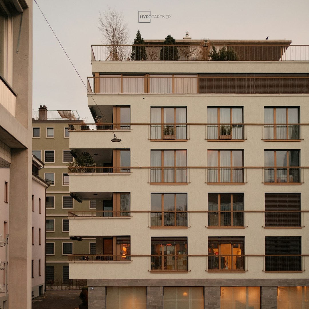 Modernes Mehrfamilienhaus mit Dachterrasse in der Abenddämmerung